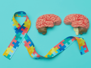 laço do autismo com cerebro representando neuroplasticidade no TDAH e TEA