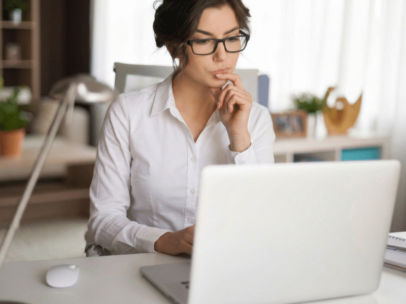 Mulher concentrada usando notebook em conteúdo sobre memória e concentração, memória fraca e suporte cognitivo individualizado.